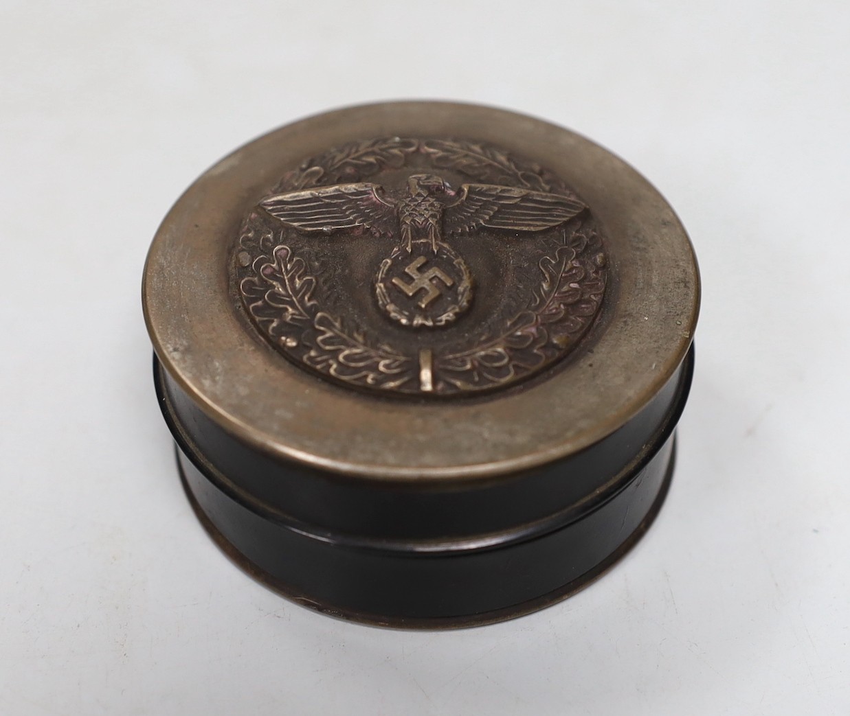 A composition and metal snuff box, with Third Reich insignia. 7cm diameter